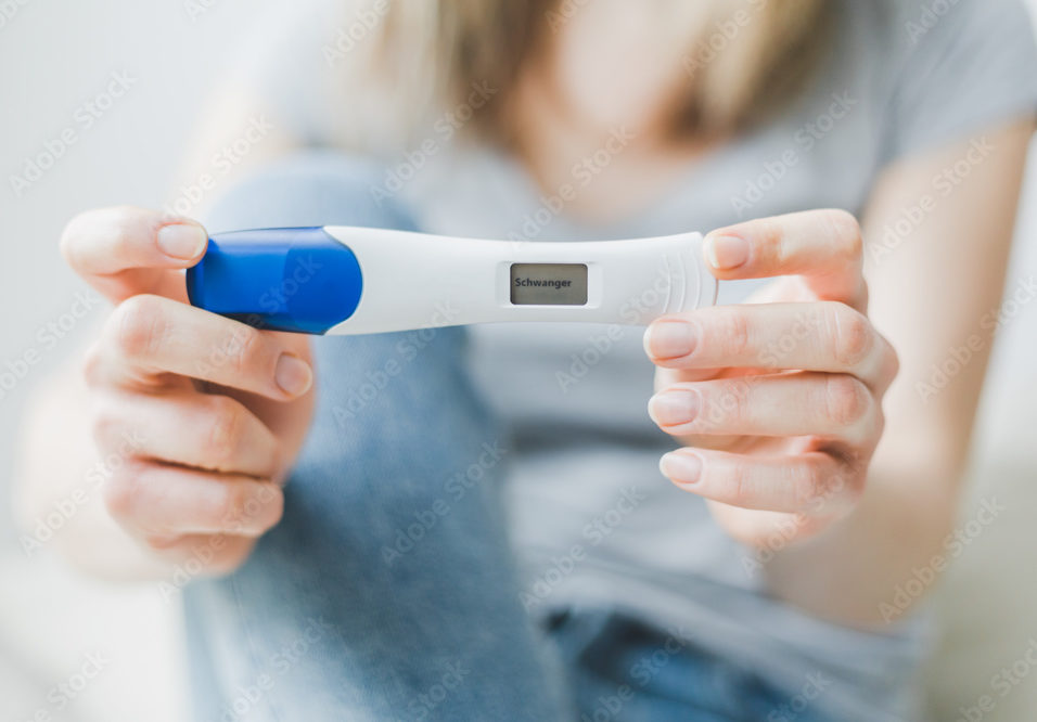 Une femme présente un test de grossesse positif